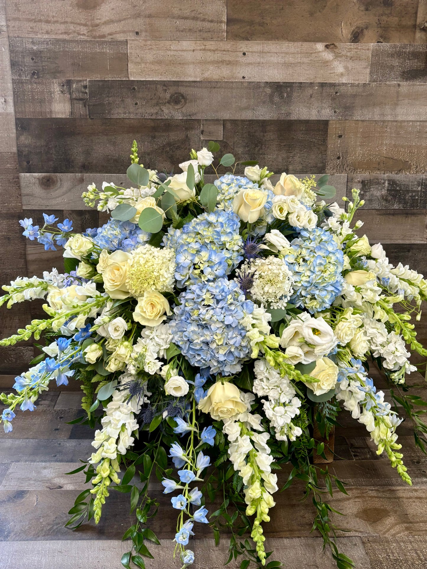 Blue and white casket spray